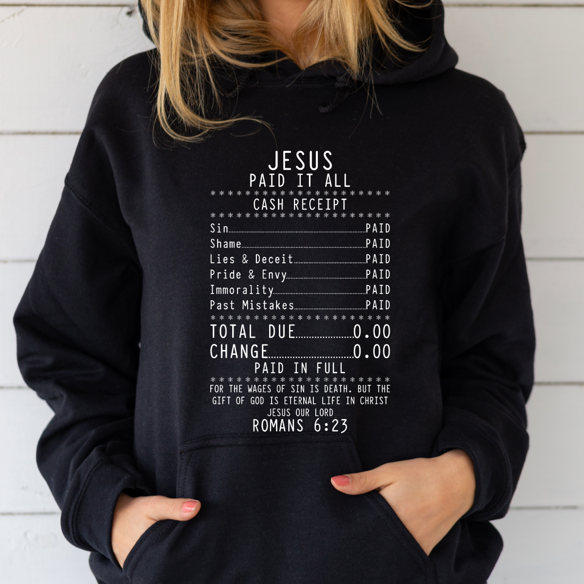 Person wearing a black hoodie with text design on a white background